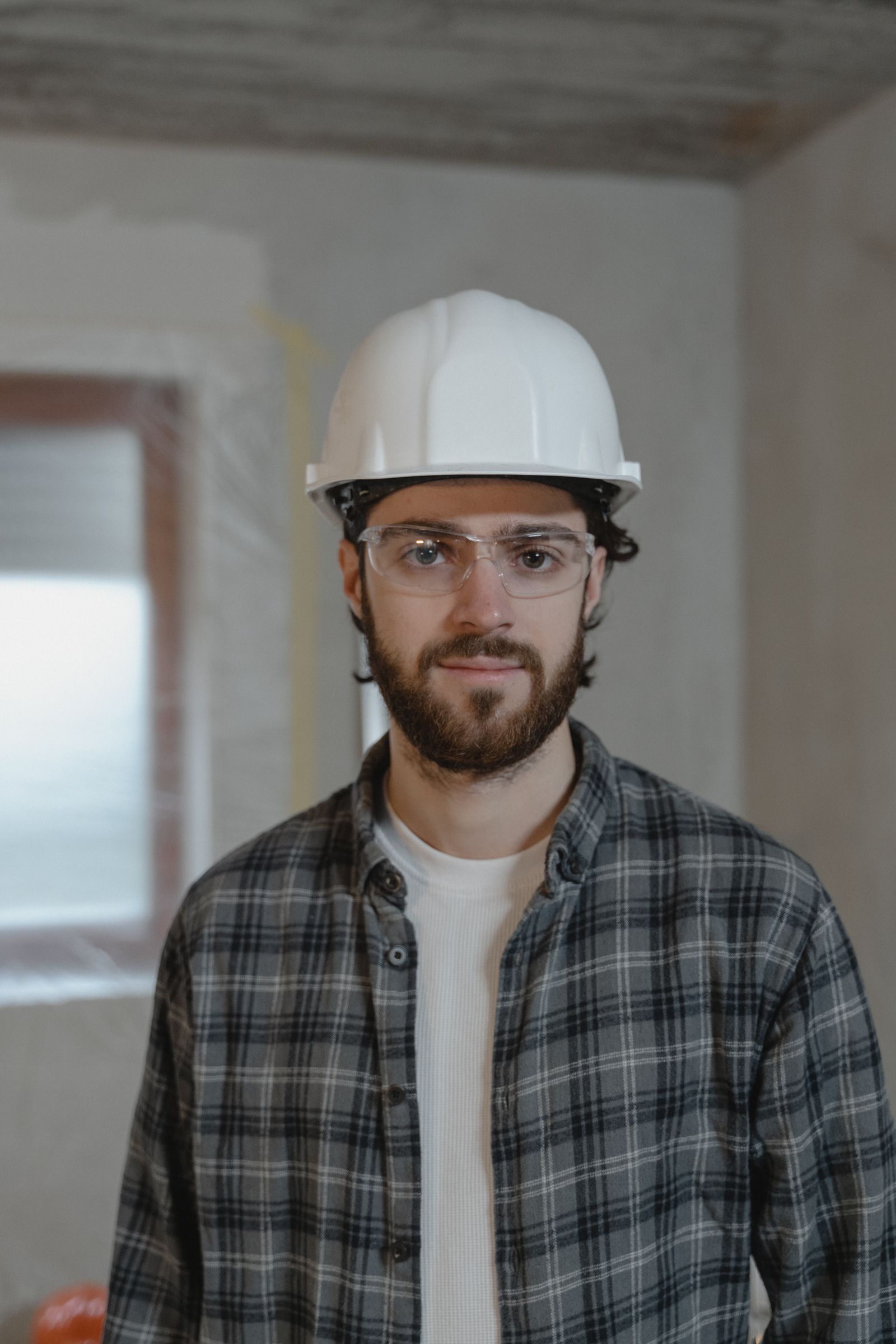 Portrait of a contractor in a white hard hat and safety glasses (placeholder photo)